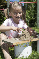 Kleines Mädchen spielt mit Sand im Garten - YFF000199