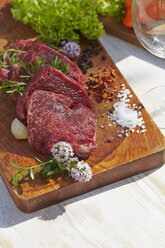 Pieces of sirloin and spices on chopping board - AKF000393