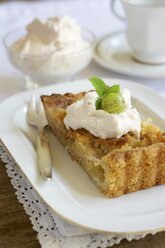 Piece of gooseberry almond tart with cream on plate - HAWF000373
