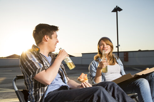 Fröhliche Teenager essen und trinken auf einem Parkplatz - FKF000571