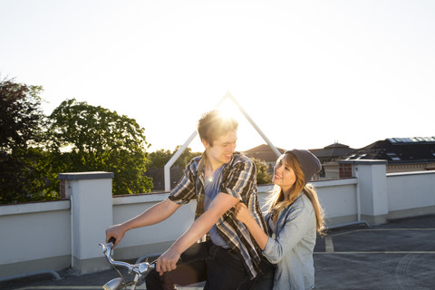 Glückliches jugendliches Paar im Freien auf dem Fahrrad, lizenzfreies Stockfoto