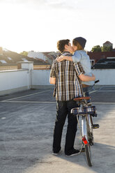 Teenagerpaar mit Fahrrad küsst sich im Freien - FKF000575