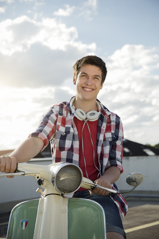 Lächelnder Jugendlicher mit Motorroller, lizenzfreies Stockfoto