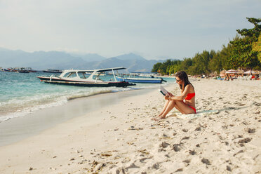Indonesien, Gili-Inseln, Frau liest ein Buch am Strand - EBSF000249