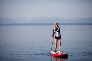 Deutschland, Bayern, junge Frau auf Stand Up Paddle Board am Starnberger See stehend - FAF000023