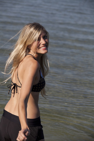 Portrait of smiling young woman in front of a lake stock photo