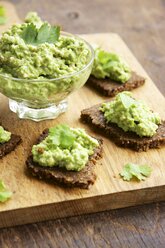 Pumpernickel-Scheiben mit Erbsen- und Walnussaufstrich auf einem Schneidebrett - HAWF000382