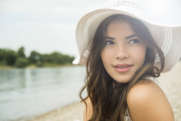 Porträt einer jungen Frau am Strand mit weißem Sommerhut - UUF001202