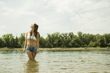 Junge Frau entspannt sich am Ufer des Rheins - UUF001213