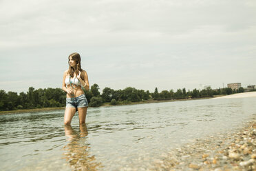 Junge Frau steht am Ufer des Rheins - UUF001214