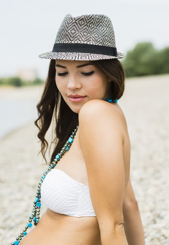 Porträt einer jungen Frau mit Hut am Strand, lizenzfreies Stockfoto