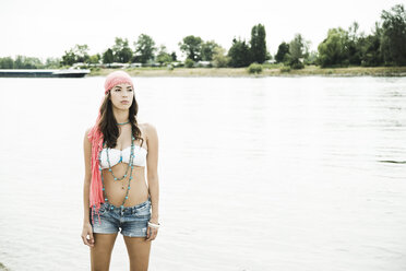 Junge Frau steht am Ufer des Rheins - UUF001286