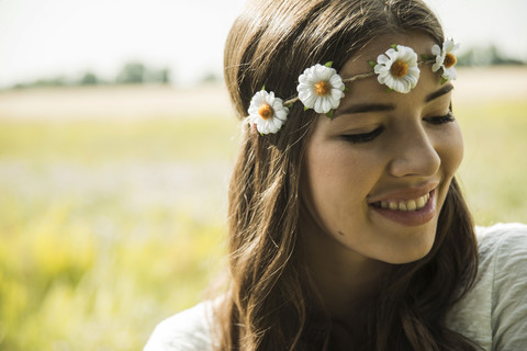 Portrait of smiling young woman wearing floral wreath stock photo