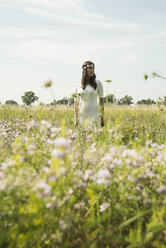 Portrait of young woman standing on flower meadow - UUF001239