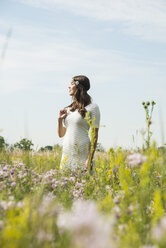 Young smiling woman standing on flower meadow - UUF001241