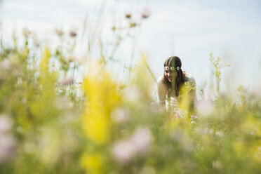 Portrait of smiling young woman standing on flower meadow - UUF001242