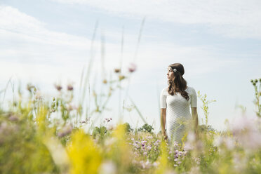 Young woman standing on flower meadow - UUF001243