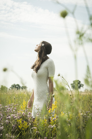Portrait of young woman relaxing on flower meadow stock photo
