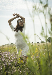 Portrait of young woman relaxing on flower meadow - UUF001247