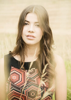 Portrait of daydreaming young woman standing on an autumnal meadow - UUF001263