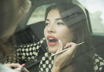 Female visagiste applying lipstick on young woman's lips - UUF001327