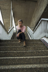 Junge Frau sitzt auf der Treppe und wartet - UUF001364