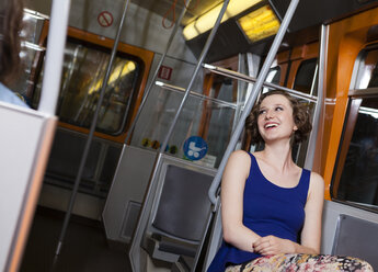 Glückliche junge Frau in einer U-Bahn - DISF000892