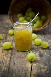 Jar of gooseberry jam, basket and organic gooseberries on dark wood - LVF001573