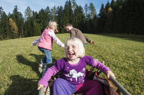 Three children playing on meadow stock photo