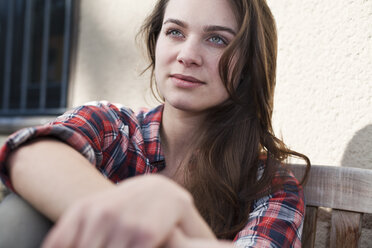 Relaxed young woman sitting outdoors - FEXF000102