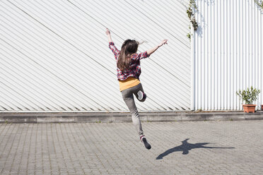 Exuberant young woman jumping outdoors - FEXF000107