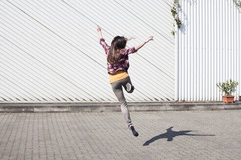 Übermütige junge Frau, die im Freien springt - FEXF000107