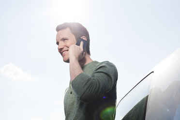 Smiling young man on cell phone - FEXF000125