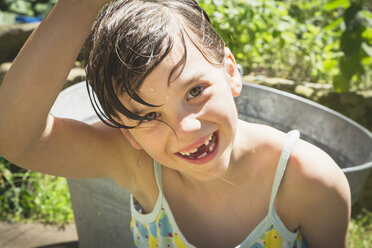 Porträt eines lachenden kleinen Mädchens mit nassen Haaren im Garten - LVF001584