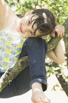 Porträt eines lächelnden kleinen Mädchens, das auf einen Baum klettert - LVF001586