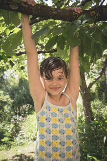Porträt eines lächelnden kleinen Mädchens, das auf einen Baum klettert - LVF001589
