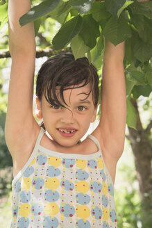 Porträt eines lächelnden kleinen Mädchens, das auf einen Baum klettert - LVF001590