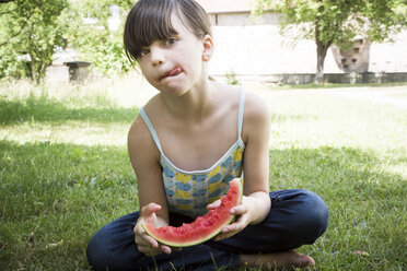 Girl with slice of watermelon licking lips - LVF001677