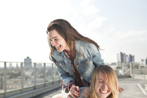 Deutschland, Nordrhein-Westfalen, Köln, zwei junge Frauen vergnügen sich auf einem Parkdeck, lizenzfreies Stockfoto