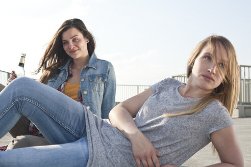 Germany, North Rhine-Westphalia, Cologne, two young women relaxing on parking level - FEXF000137