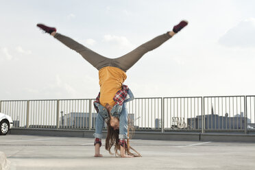 Deutschland, Nordrhein-Westfalen, Köln, junge Frau im Handstand auf einem Parkdeck - FEXF000142