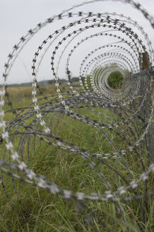 Germany, Bavaria, Oberpfaffenhofen, Barbed wire fence at airport - CRF002597