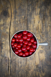 Metal jar of red currants, Ribes rubrum, on dark wooden table, elevated view - LVF001607