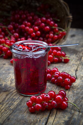 Marmeladenglas mit Johannisbeergelee und roten Johannisbeeren, Ribes rubrum, auf Holztisch - LVF001611