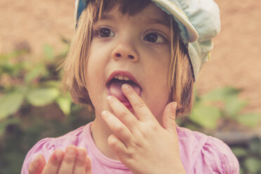Porträt eines kleinen Mädchens, das rote Johannisbeeren isst - LVF001626