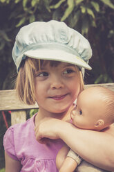 Portrait of little girl having doll in her arm - LVF001631