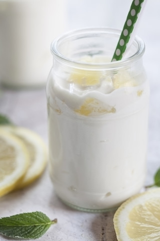 Zitronenjoghurt mit Zitronenscheiben und Minzblättern, lizenzfreies Stockfoto