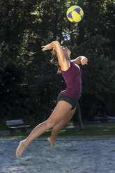 Germany, Young woman playing beach volleyball - STSF000448