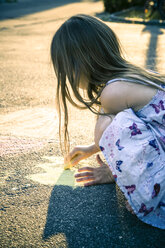 Kleines Mädchen malt mit Buntstiften auf dem Asphalt - SARF000734