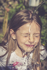 Kleines Mädchen erfrischt ihr Gesicht mit einem Wasserstrahl - SARF000731